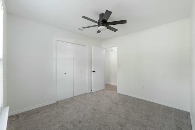 unfurnished bedroom with ceiling fan, a closet, and light colored carpet