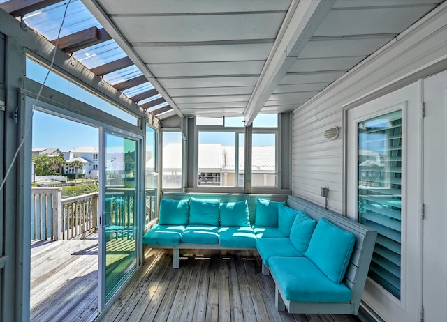 sunroom / solarium featuring vaulted ceiling with beams