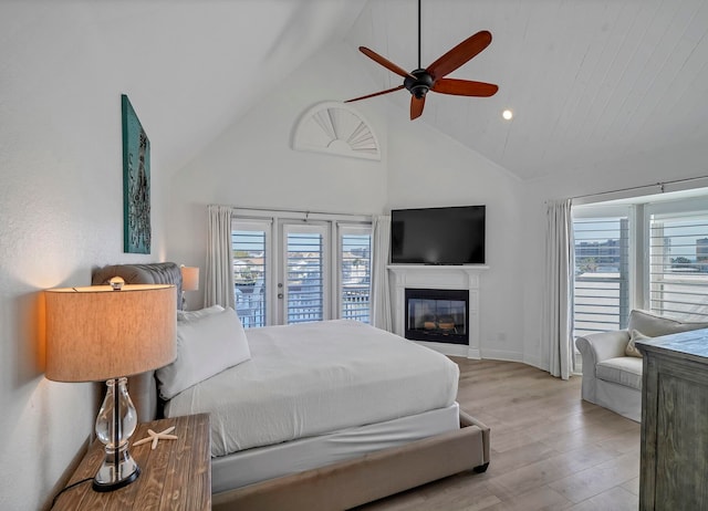 bedroom featuring ceiling fan, access to exterior, high vaulted ceiling, and light hardwood / wood-style flooring