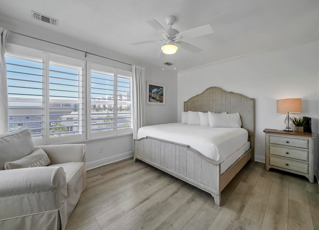 bedroom featuring ceiling fan, multiple windows, and light hardwood / wood-style flooring