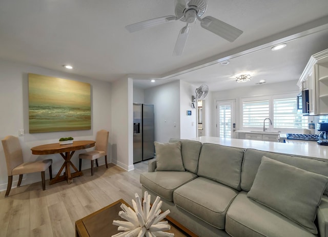 living room with ceiling fan and light wood-type flooring