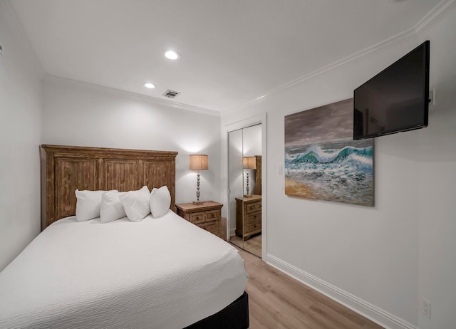 bedroom featuring a closet, crown molding, and light hardwood / wood-style flooring