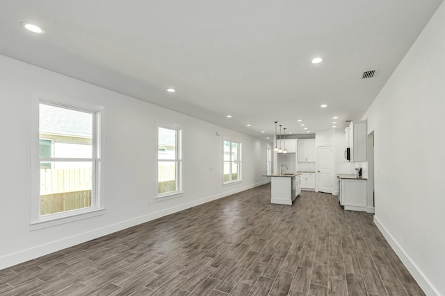 unfurnished living room featuring dark hardwood / wood-style floors and sink