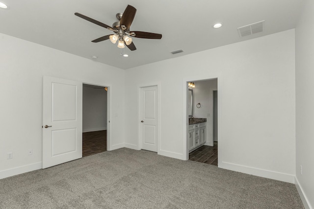 unfurnished bedroom featuring connected bathroom, ceiling fan, a closet, and dark colored carpet