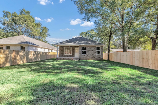 rear view of property featuring a lawn