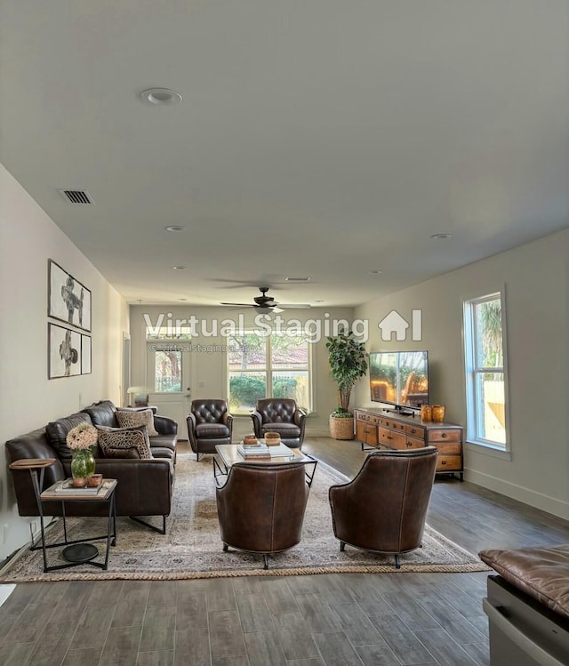 living room featuring a healthy amount of sunlight, visible vents, and wood finished floors