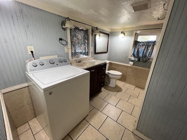 laundry room featuring light tile patterned flooring, sink, and washer / clothes dryer