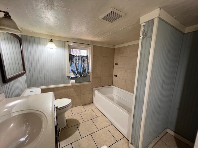 bathroom featuring vanity, tile patterned flooring, a bathtub, and toilet