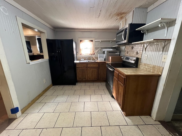 kitchen featuring tasteful backsplash, wood walls, light tile patterned floors, and appliances with stainless steel finishes