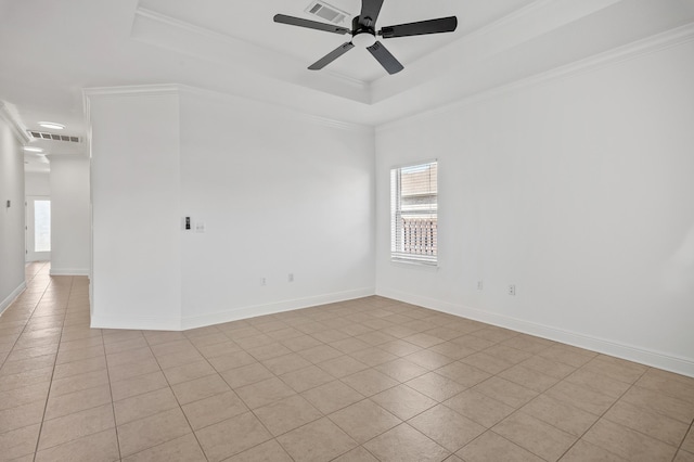 empty room with light tile patterned floors, crown molding, and a tray ceiling