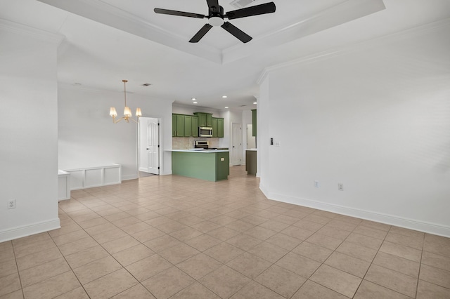 unfurnished living room featuring ceiling fan with notable chandelier, a tray ceiling, crown molding, and light tile patterned flooring