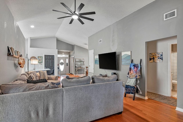 living room featuring hardwood / wood-style flooring, ceiling fan, a textured ceiling, and high vaulted ceiling