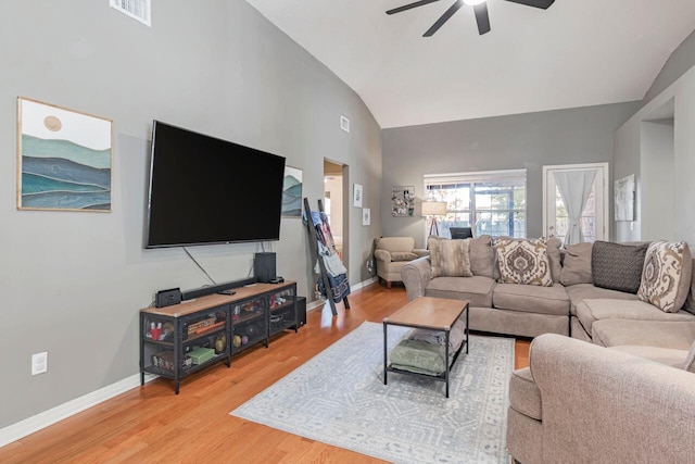 living room with hardwood / wood-style flooring, ceiling fan, and high vaulted ceiling