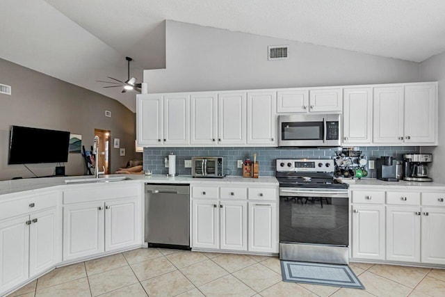 9761 Leeward Way, Navarre, FL 32566 - kitchen featuring stainless steel appliances, vaulted ceiling, decorative backsplash, light countertops, and a ceiling fan