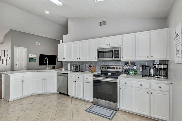 9761 Leeward Way, Navarre, FL 32566 - kitchen featuring stainless steel appliances, a sink, a peninsula, backsplash, and white cabinets