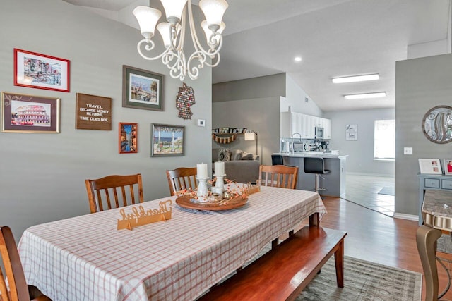 9761 Leeward Way, Navarre, FL 32566 - dining room with vaulted ceiling, wood finished floors, a chandelier, baseboards, and recessed lighting