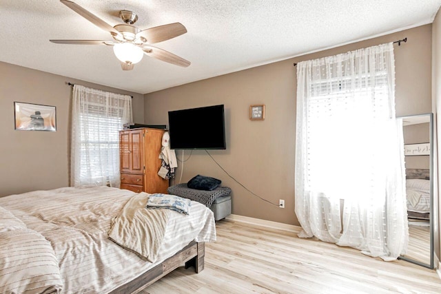 9761 Leeward Way, Navarre, FL 32566 - bedroom featuring wood finished floors, a textured ceiling, baseboards, and ceiling fan