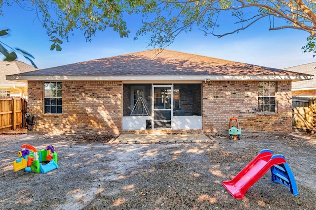 9761 Leeward Way, Navarre, FL 32566 - back of property with brick siding, a sunroom, and a shingled roof