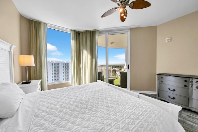 bedroom featuring hardwood / wood-style floors, ceiling fan, expansive windows, and access to outside