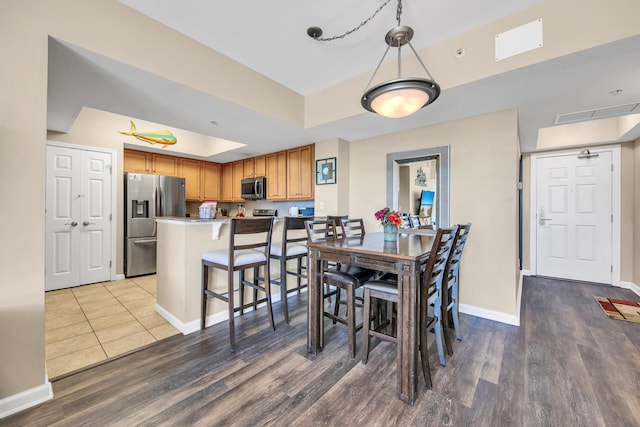 4207 Indian Bayou Trl Unit 2216, Destin, FL 32541 - dining area featuring wood finished floors, baseboards, and a raised ceiling