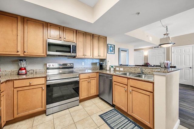 4207 Indian Bayou Trl Unit 2216, Destin, FL 32541 - kitchen featuring appliances with stainless steel finishes, a sink, a peninsula, backsplash, and hanging light fixtures