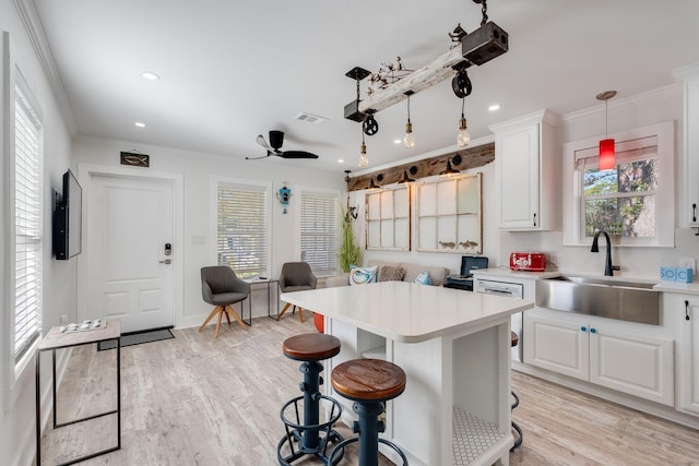 kitchen with ceiling fan, sink, hanging light fixtures, light hardwood / wood-style floors, and white cabinets