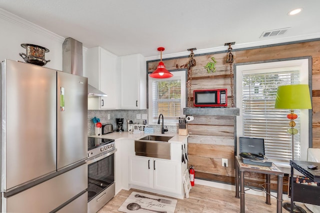 kitchen featuring pendant lighting, plenty of natural light, white cabinetry, and appliances with stainless steel finishes