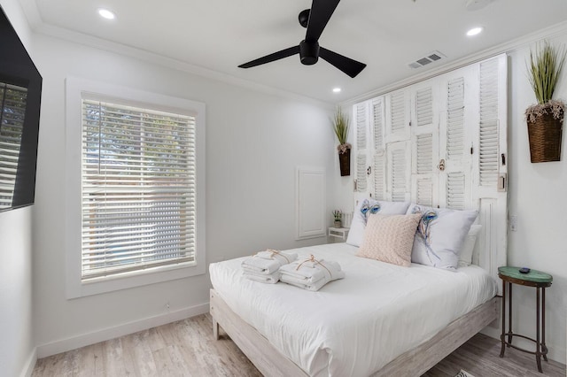bedroom with wood-type flooring, ceiling fan, and crown molding