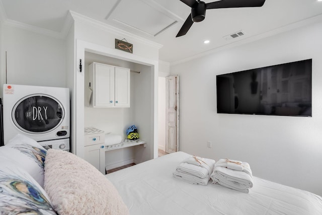 bedroom with ceiling fan, crown molding, and stacked washer and clothes dryer