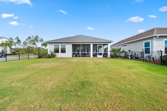 back of property with a lawn and a sunroom