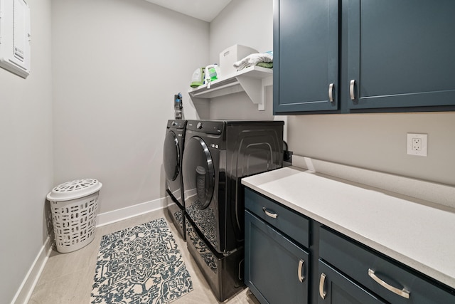 laundry area featuring cabinets, separate washer and dryer, and light tile patterned floors