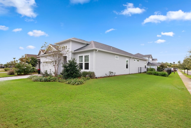 view of side of home featuring a garage and a lawn