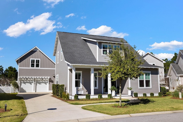 view of front of property featuring covered porch, a garage, and a front lawn