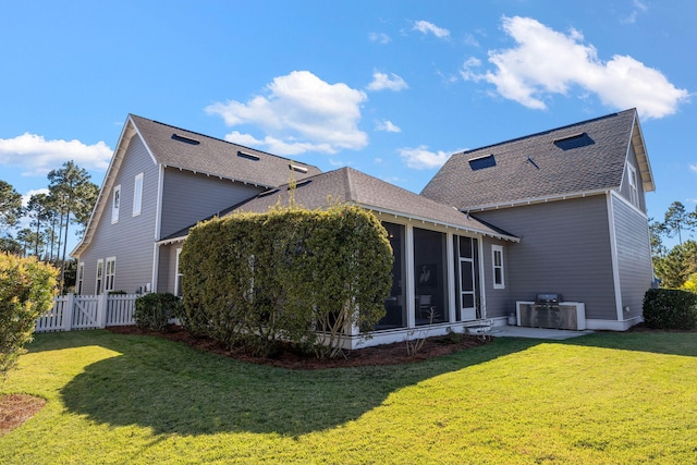 back of house featuring a sunroom, a patio area, a yard, and central air condition unit