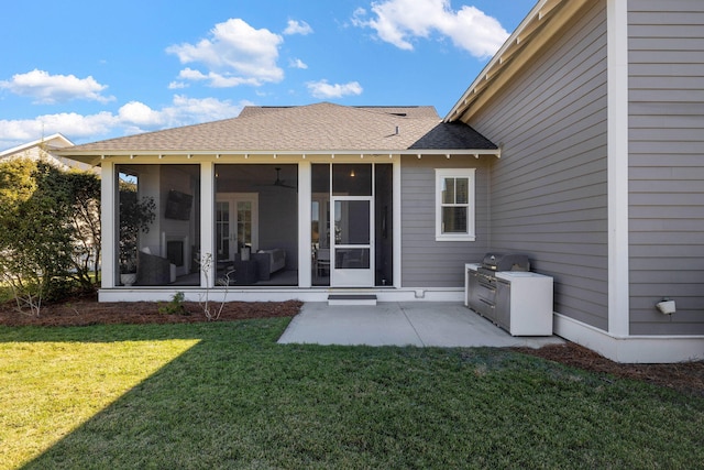 rear view of property with a sunroom, a yard, exterior kitchen, and a patio