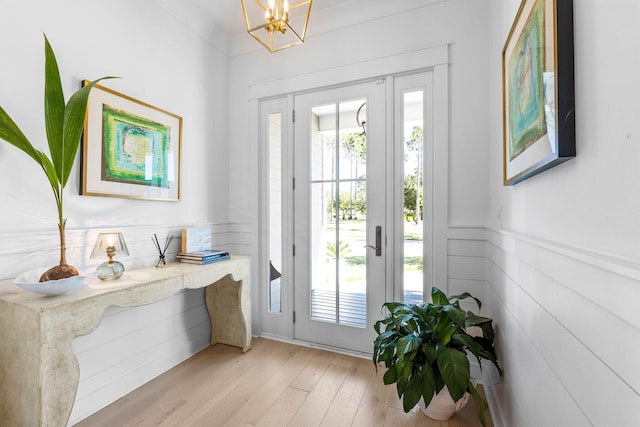 entryway with light hardwood / wood-style floors and an inviting chandelier