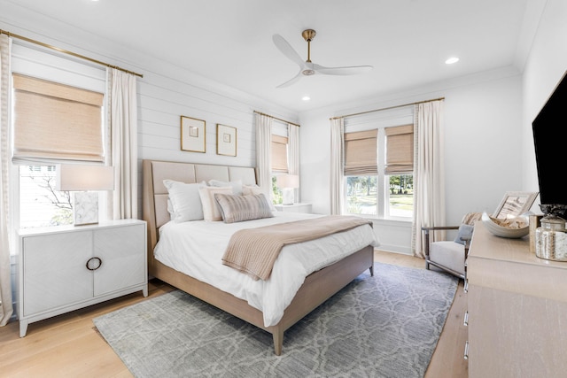 bedroom with ceiling fan, crown molding, and light hardwood / wood-style flooring