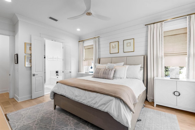 bedroom with connected bathroom, light hardwood / wood-style floors, ceiling fan, and ornamental molding