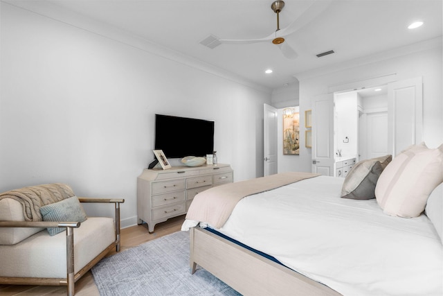 bedroom featuring a walk in closet, ceiling fan, light hardwood / wood-style flooring, and ornamental molding