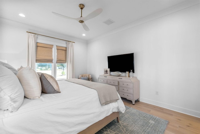 bedroom with ceiling fan, light wood-type flooring, and ornamental molding