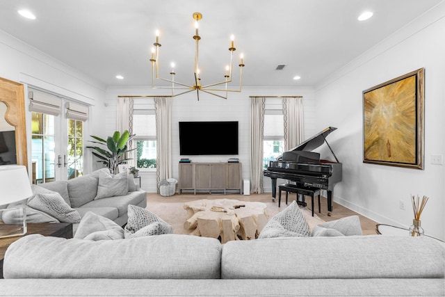 living room with light hardwood / wood-style flooring, ornamental molding, french doors, and a notable chandelier