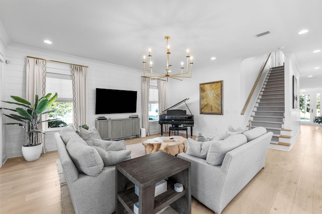 living room featuring light hardwood / wood-style floors, crown molding, and a notable chandelier