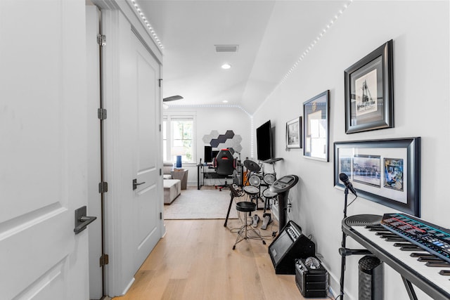 hall featuring light hardwood / wood-style flooring and vaulted ceiling