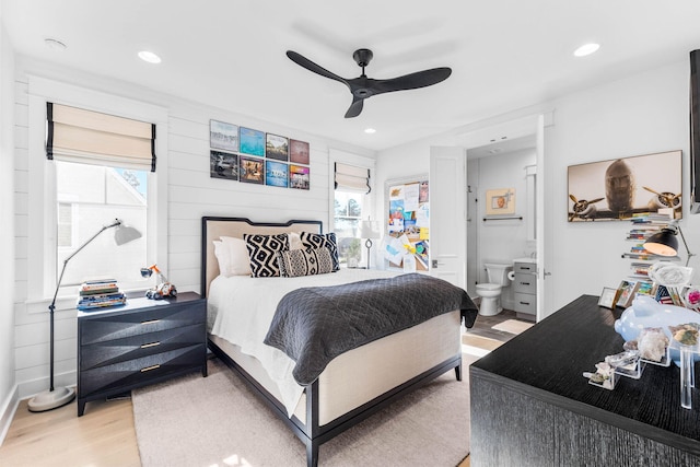 bedroom with ceiling fan, light hardwood / wood-style flooring, and ensuite bathroom