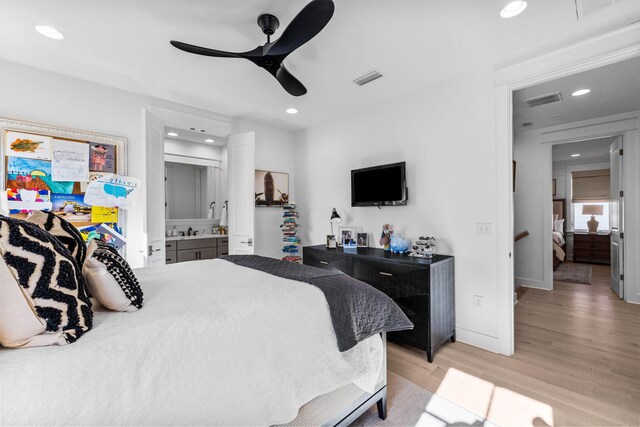 bedroom with ensuite bath, ceiling fan, sink, and light wood-type flooring