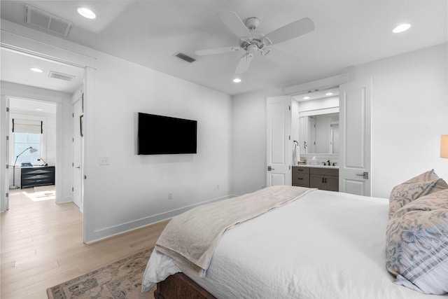 bedroom with ceiling fan, light hardwood / wood-style floors, sink, and ensuite bathroom