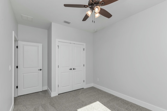 unfurnished bedroom with light carpet, a closet, and ceiling fan