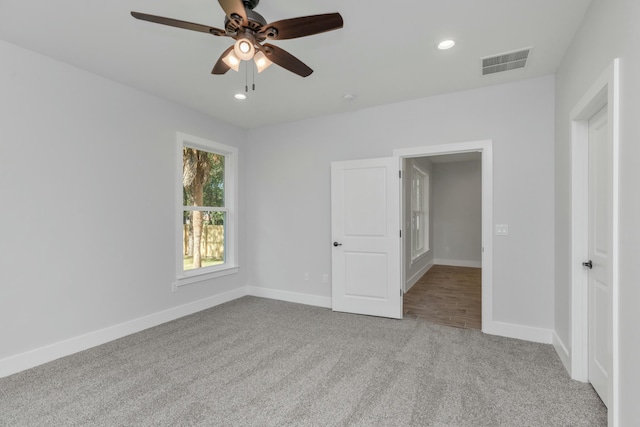 unfurnished bedroom with ceiling fan and light carpet