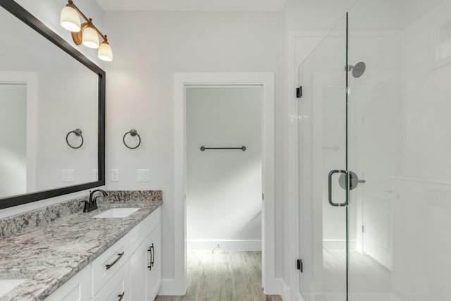 bathroom featuring vanity, wood-type flooring, and walk in shower