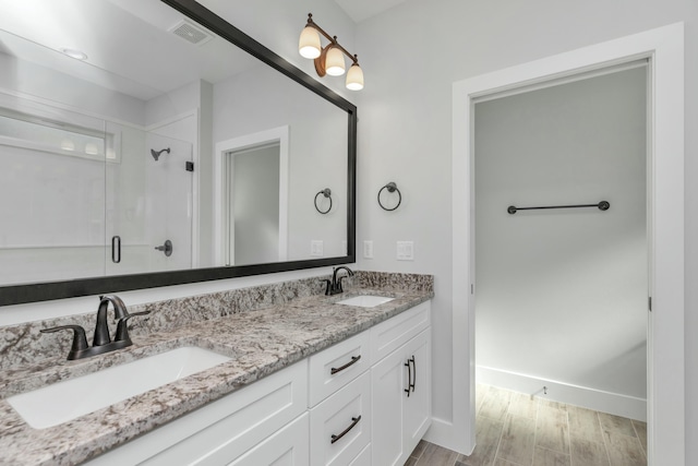 bathroom with vanity, hardwood / wood-style flooring, and a shower with shower door